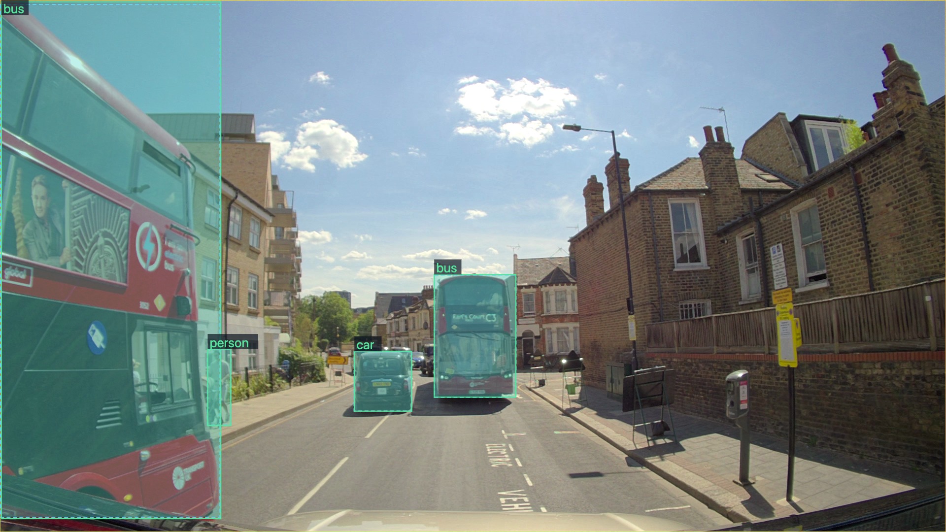 Road scene with buses, a car and a pedestrian highlighted by object detection boxes.